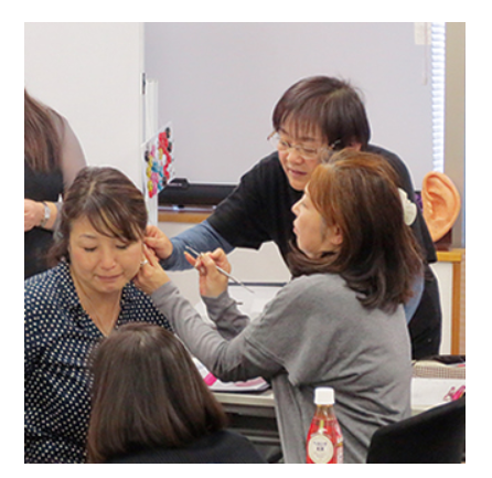 耳つぼの施術をやり合っている画像