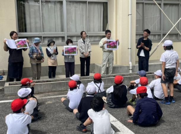 小学生に草花のことを説明している画像
