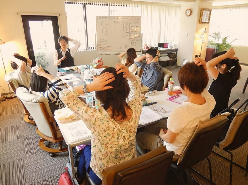 西川先生と少人数の生徒さんでヘッドセラピーを学んでいる画像