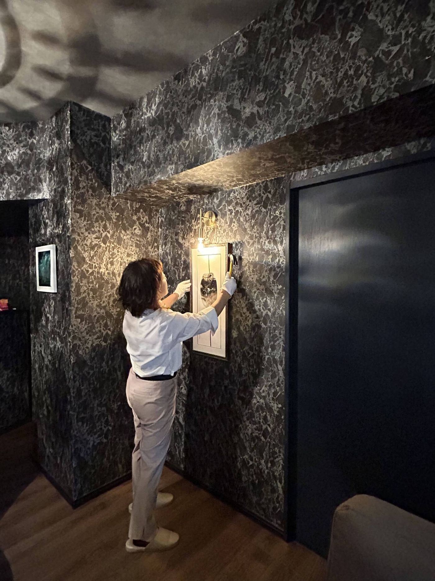 お客様の部屋でアートを飾る枝澤氏