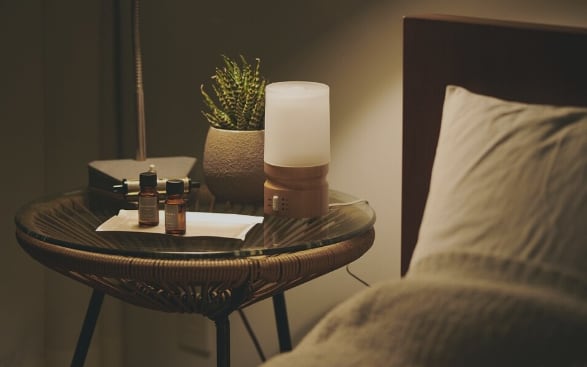 寝室のベッドサイドにアロマが置いてある画像