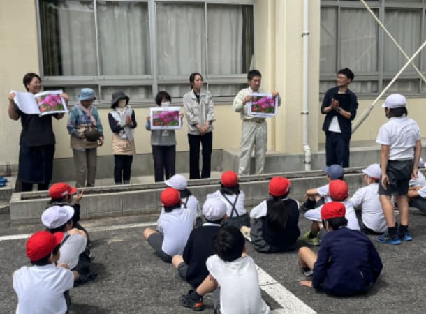 小学生に草花のことを説明している画像