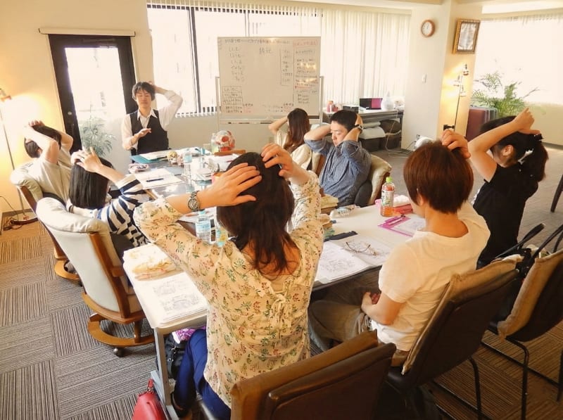 西川先生と少人数の生徒さんでヘッドセラピーを学んでいる画像